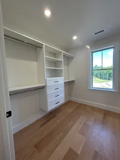a view of an empty room with a cabinet and a window
