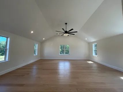 an empty room with a ceiling fan and a window