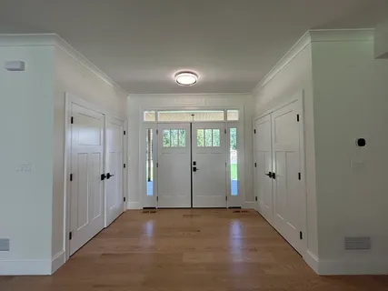 an empty room with windows and fireplace