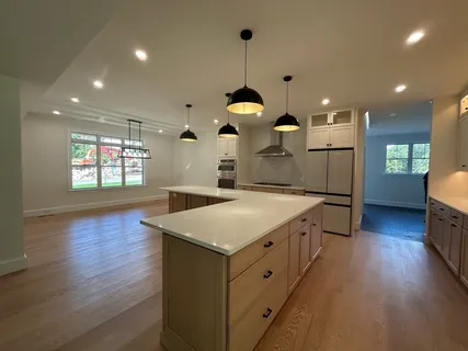 a kitchen with stainless steel appliances wooden floor sink and wooden cabinets