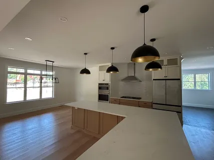 a kitchen with stainless steel appliances wooden floor sink and wooden cabinets