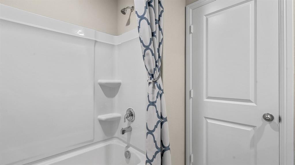 557 Marsh Street Cleburne, TX 76033 - Photo 28 of 40 a bathroom with a bathtub and shower
