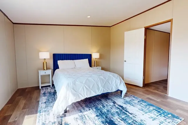 a bedroom with a bed and wooden floor