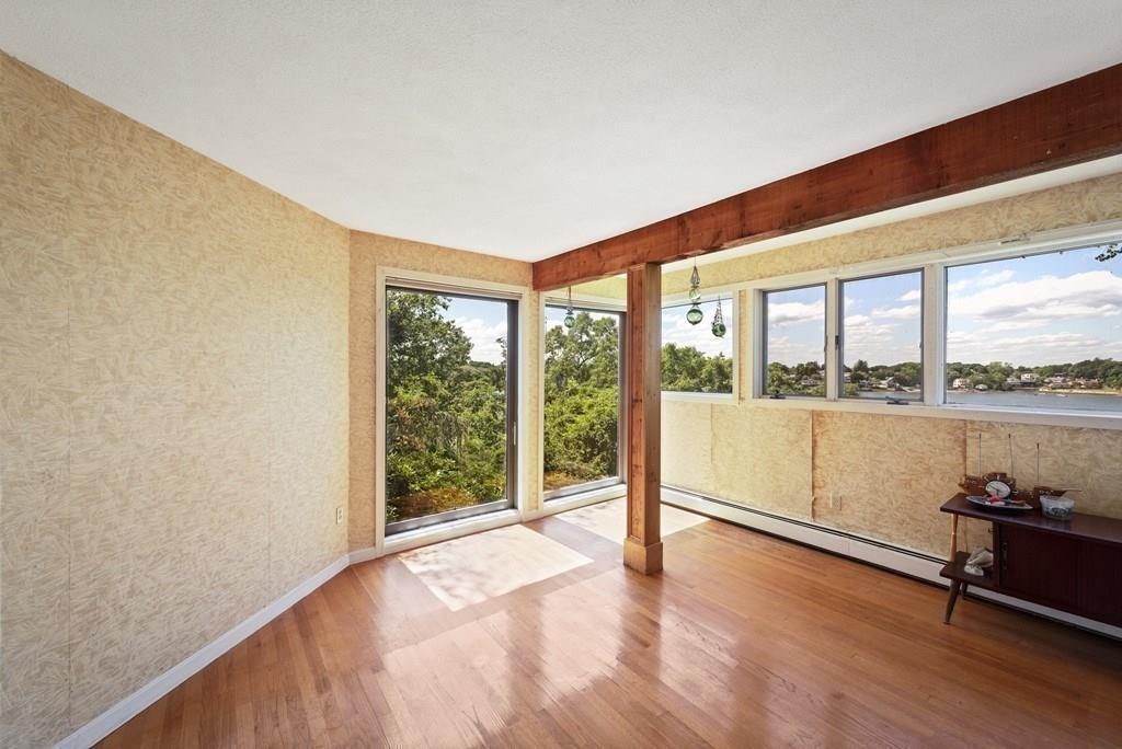 50 Pinecliff Drive Marblehead, MA 01945 - Photo 22 of 41 an empty room with wooden floor and windows with lake view