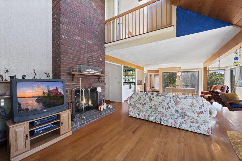 50 Pinecliff Drive Marblehead, MA 01945 - Photo 10 of 41 a living room with furniture flat screen tv and a fireplace