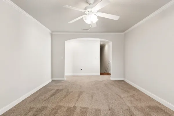 an empty room with a window and a ceiling fan