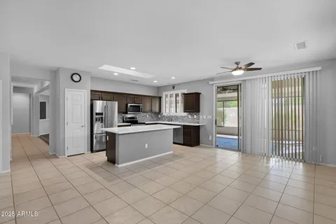 a large white kitchen with a sink stainless steel appliances and cabinets