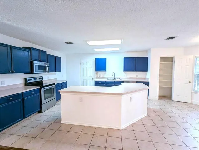 a large kitchen with cabinets and stainless steel appliances