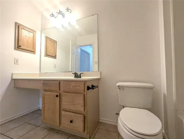 a bathroom with a toilet a sink a vanity and mirror