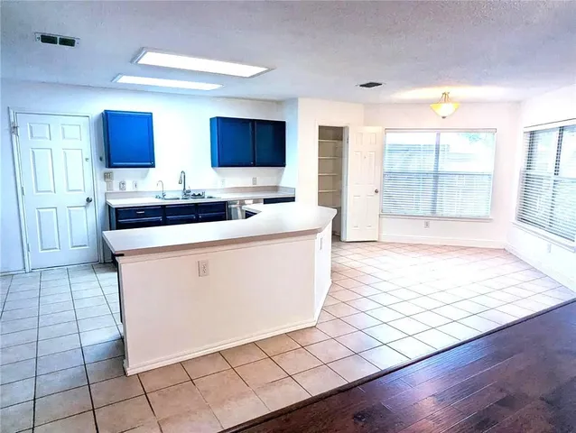 a living room with stainless steel appliances kitchen island granite countertop a sink and a stove top oven