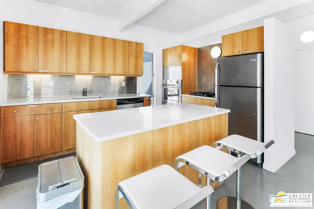 a kitchen with a sink a refrigerator and a stove top oven