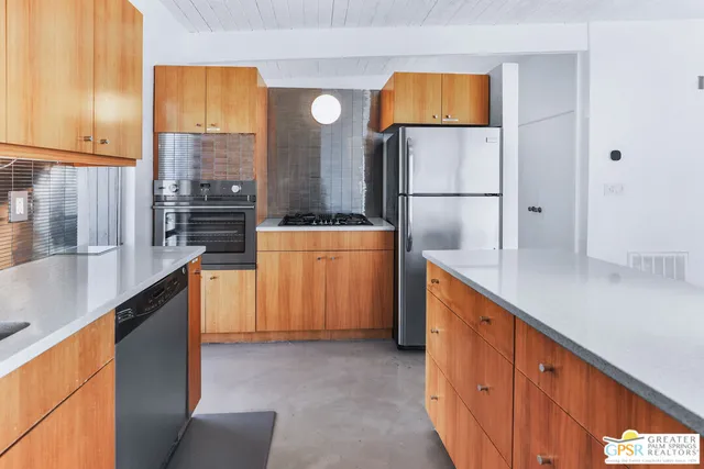 a kitchen with stainless steel appliances granite countertop a refrigerator and a stove