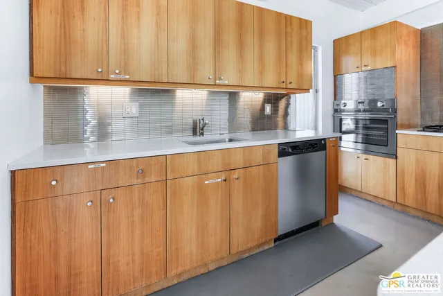 a kitchen with stainless steel appliances granite countertop a refrigerator a sink and cabinets