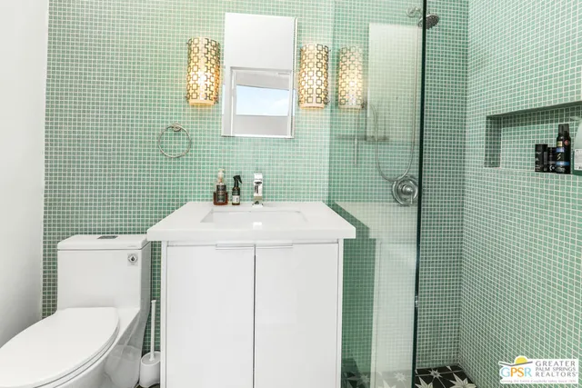 a bathroom with a sink a toilet and shower