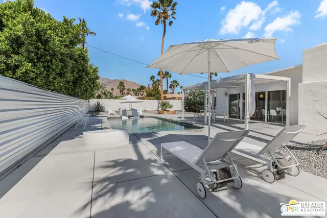 a view of a house with pool and sitting area
