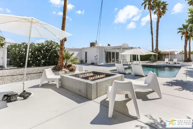 a view of a patio with a table and chairs under an umbrella