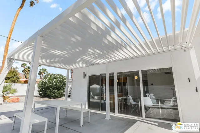 a backyard of a house with table and chairs