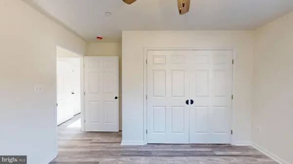 a view of an empty room with wooden floor and window