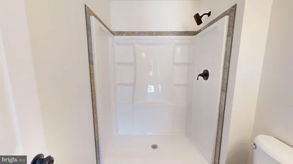 a view of an empty room with window and a chandelier fan