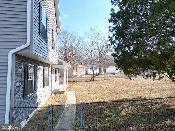 a large kitchen with a large window a sink dishwasher a stove and white cabinets with wooden floor