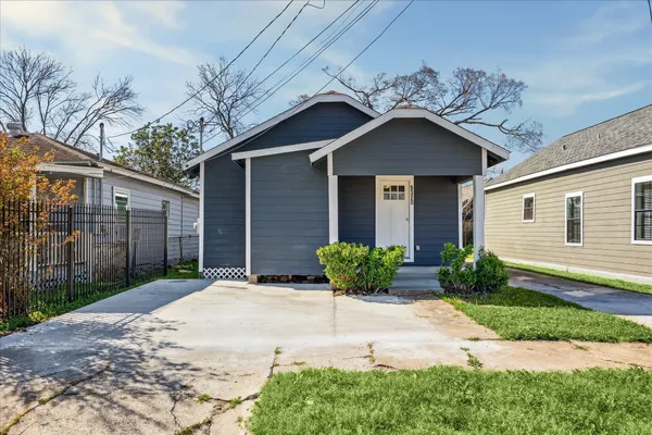 a front view of a house with a yard and potted plants