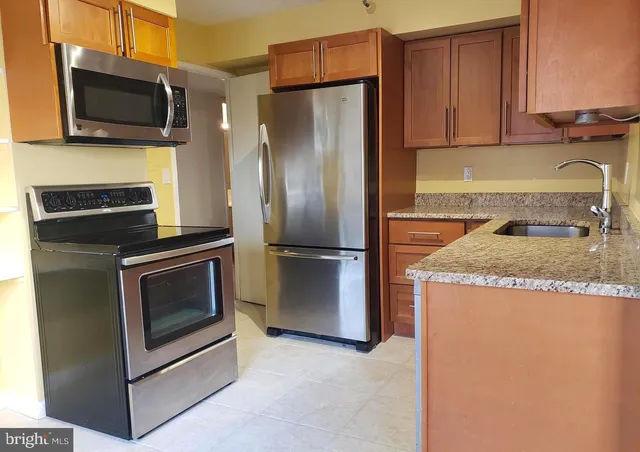 a kitchen with stainless steel appliances granite countertop a refrigerator stove and microwave