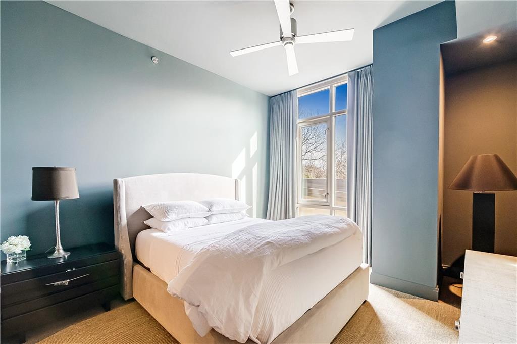 905 Juniper Street Northeast, Unit 405 Atlanta, GA 30309 - Photo 13 of 34 a bedroom with a bed and a night stand