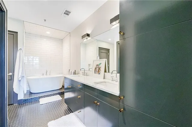 a spacious bathroom with a double vanity sink a mirror and a bathtub