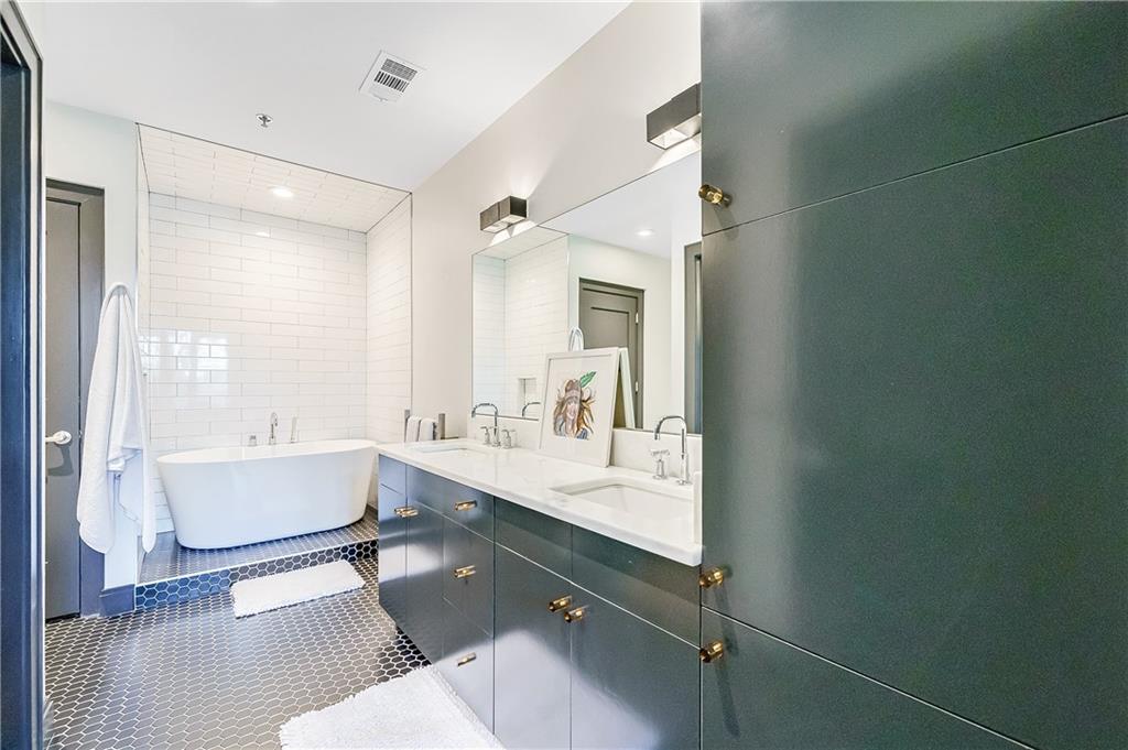 905 Juniper Street Northeast, Unit 405 Atlanta, GA 30309 - Photo 15 of 34 a spacious bathroom with a double vanity sink a mirror and a bathtub