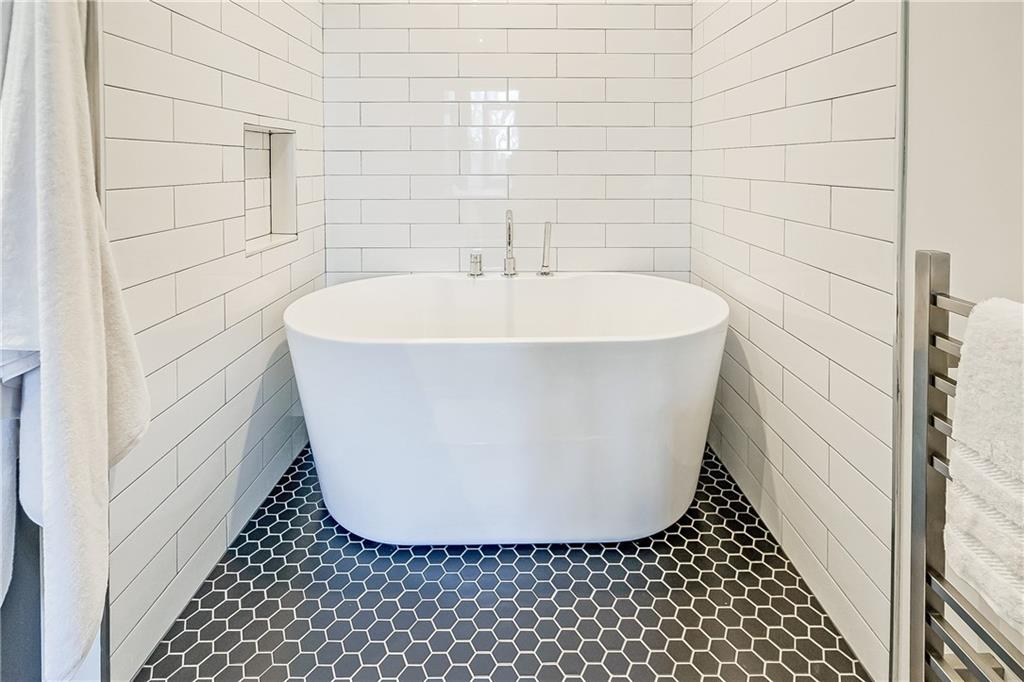 905 Juniper Street Northeast, Unit 405 Atlanta, GA 30309 - Photo 17 of 34 a white bath tub sitting in a bathroom