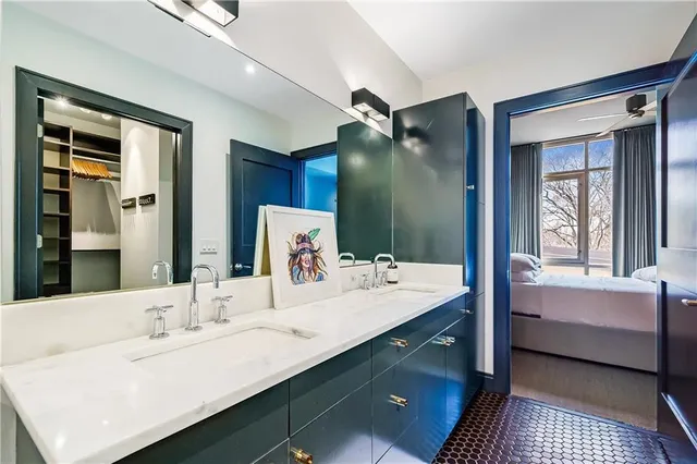 a en suite bathroom with a double vanity sink a mirror and a bathtub
