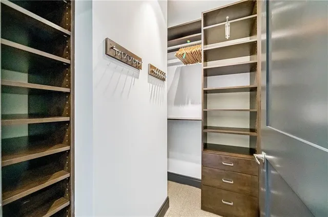 a view of walk in closet with empty racks