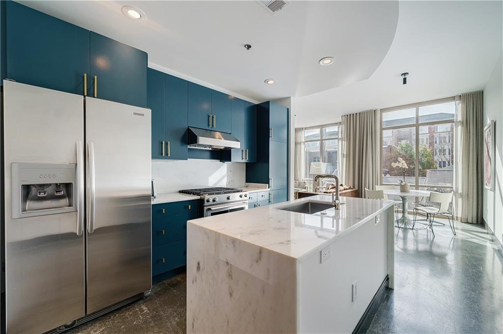 905 Juniper Street Northeast, Unit 405 Atlanta, GA 30309 - Photo 2 of 34 a kitchen with a refrigerator a stove a sink and a microwave