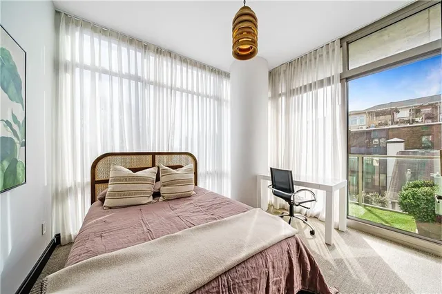 a bedroom with a bed and a large window