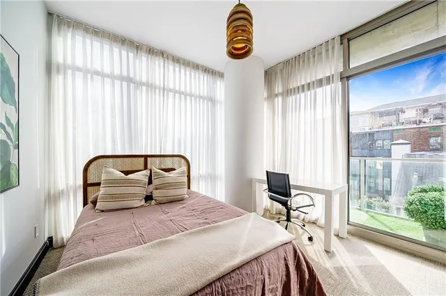 a bedroom with a bed and a large window