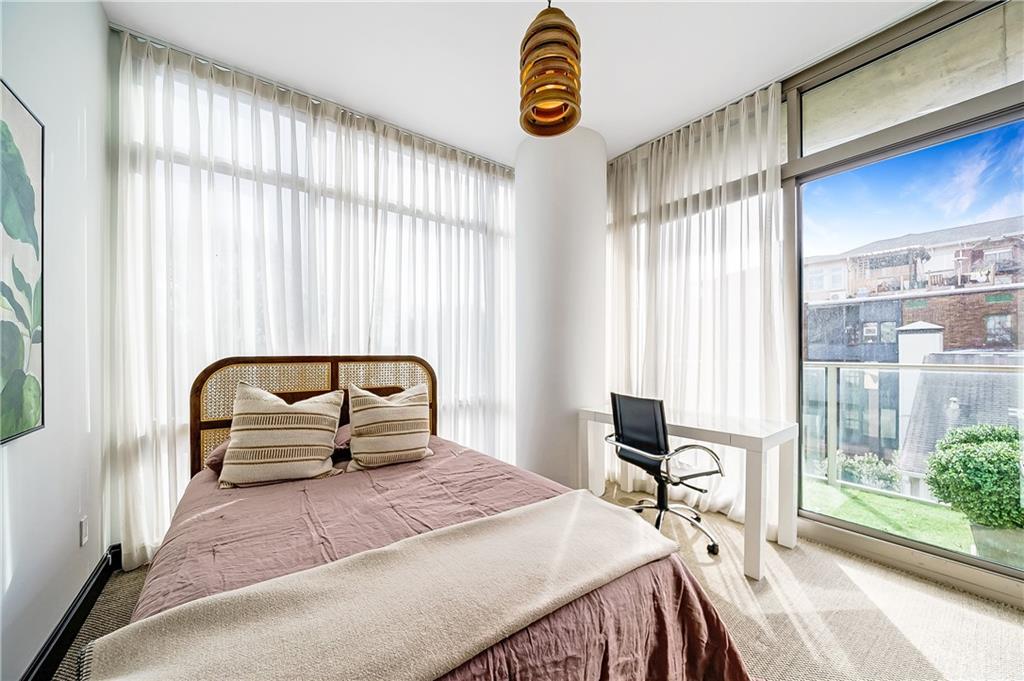 905 Juniper Street Northeast, Unit 405 Atlanta, GA 30309 - Photo 22 of 34 a bedroom with a bed and a large window