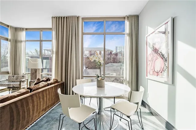 a dining room with wooden floor and large windows