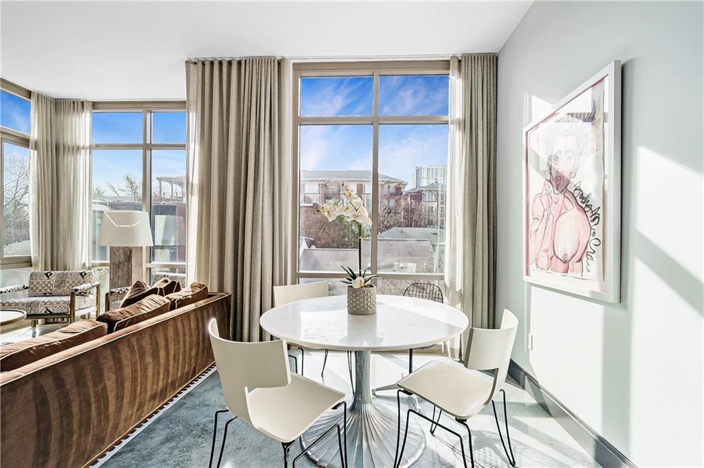 905 Juniper Street Northeast, Unit 405 Atlanta, GA 30309 - Photo 5 of 34 a dining room with wooden floor and large windows