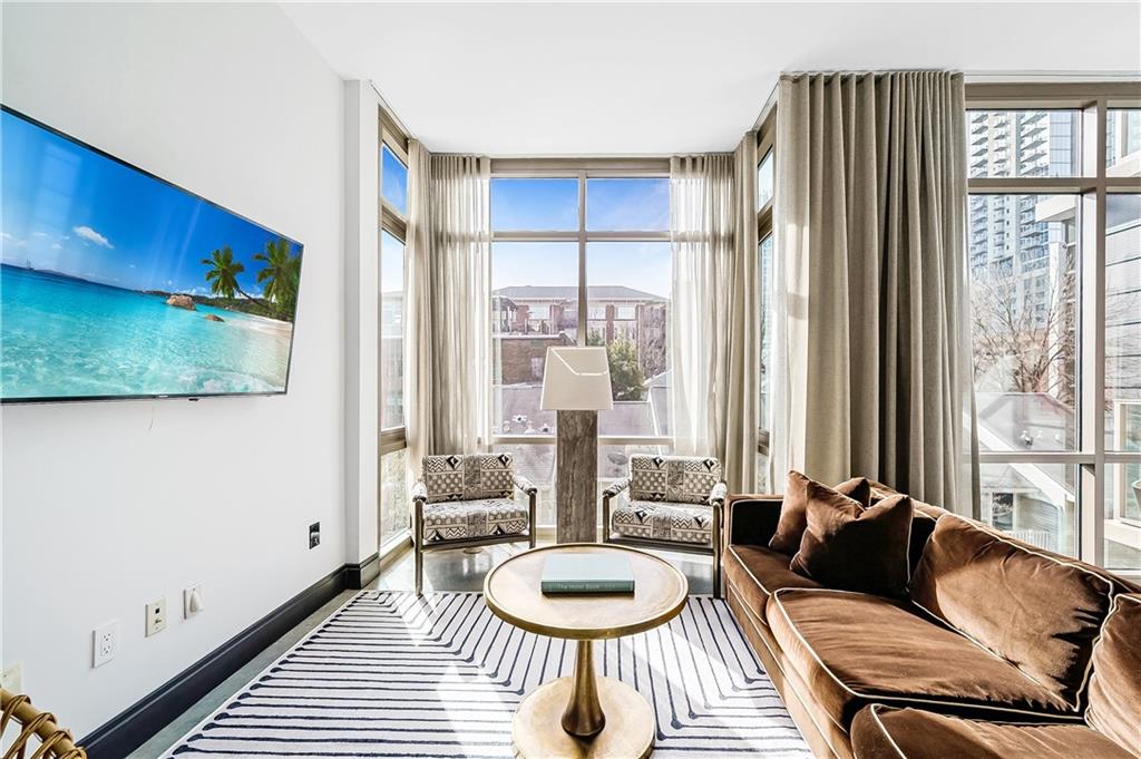 905 Juniper Street Northeast, Unit 405 Atlanta, GA 30309 - Photo 8 of 34 a living room with furniture and a large window