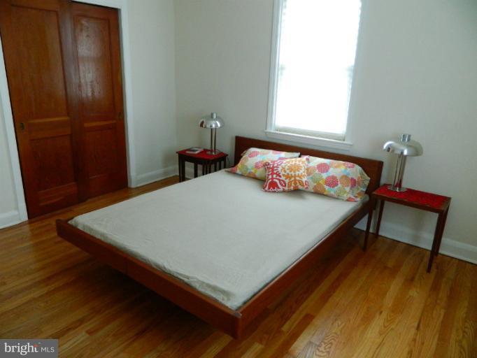 729 Charing Cross Road Baltimore, MD 21229 - Photo 2 of 26 a bedroom with a bed and wooden floor