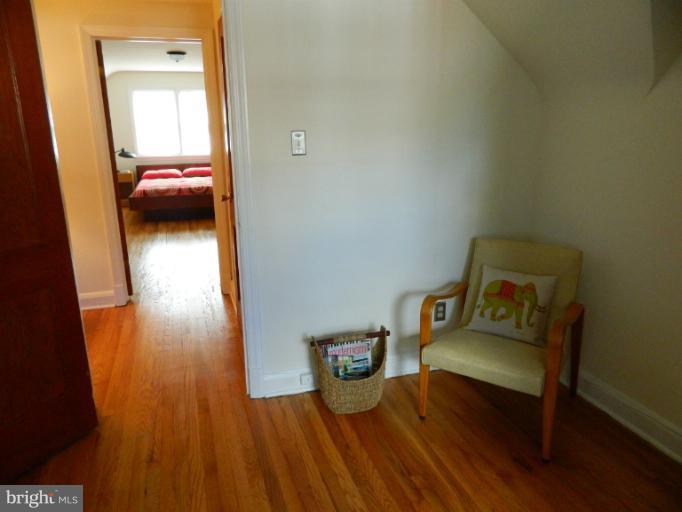 729 Charing Cross Road Baltimore, MD 21229 - Photo 15 of 26 a hallway with a bed and wooden floor
