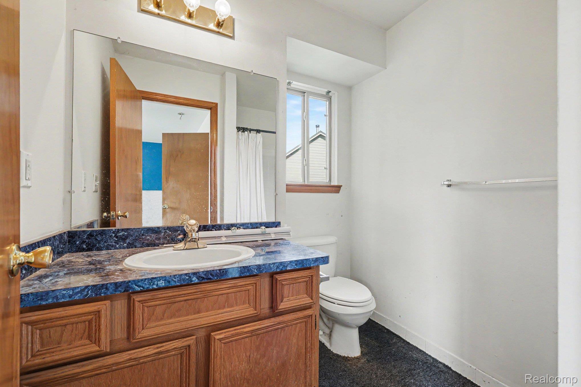 28355 Gamble Road New Baltimore, MI 48047 - Photo 12 of 18 Vanity with a built-in sink, wood-finish cabinetry, and a blue patterned countertop