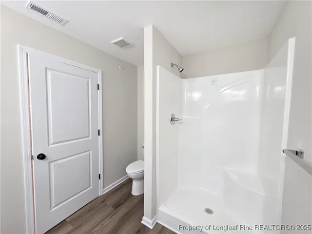 a bathroom with a shower a toilet and a sink