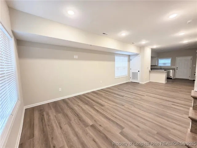 a view of empty room with wooden floor