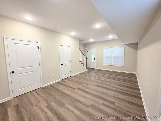 an empty room with wooden floor and cabinet