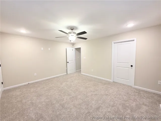 a view of an empty room with a chandelier fan