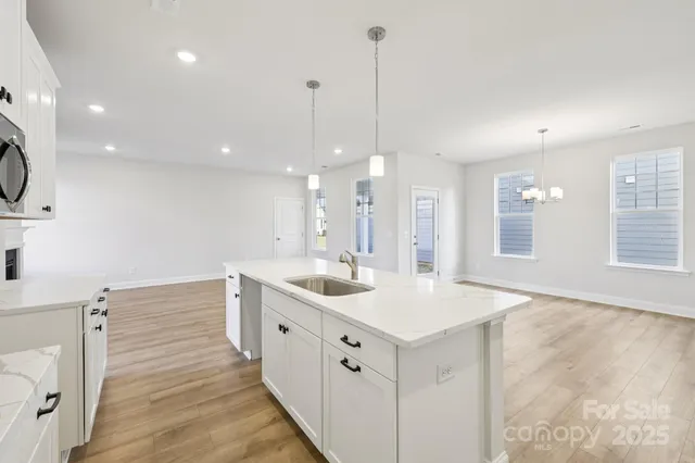 a kitchen that has a lot of white cabinets and wooden floor