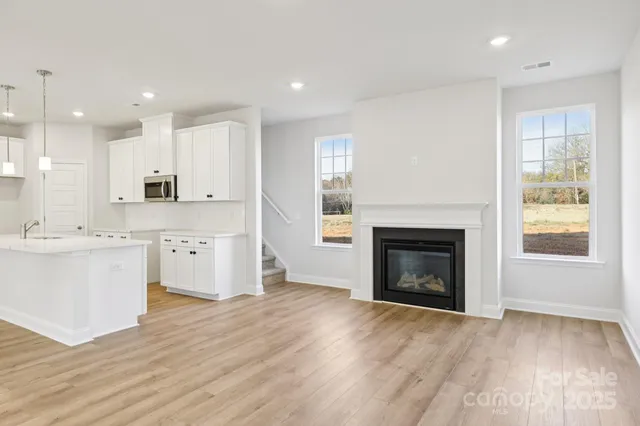 a large kitchen with a refrigerator a stove top oven a sink and a fireplace