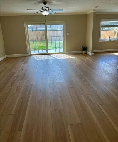 an empty room with wooden floor and a window