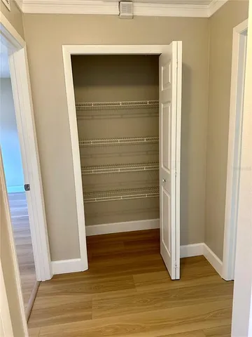 a view of walk in closet with wooden floor